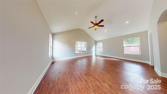 empty room featuring dark wood-type flooring, ceiling fan, and vaulted ceiling