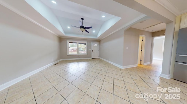 spare room featuring crown molding, light tile patterned floors, ceiling fan, and a tray ceiling