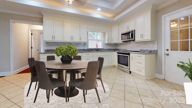 kitchen with stainless steel appliances, white cabinetry, and light tile patterned flooring