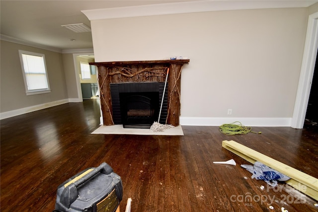 unfurnished living room featuring wood finished floors, ornamental molding, a fireplace with flush hearth, and baseboards