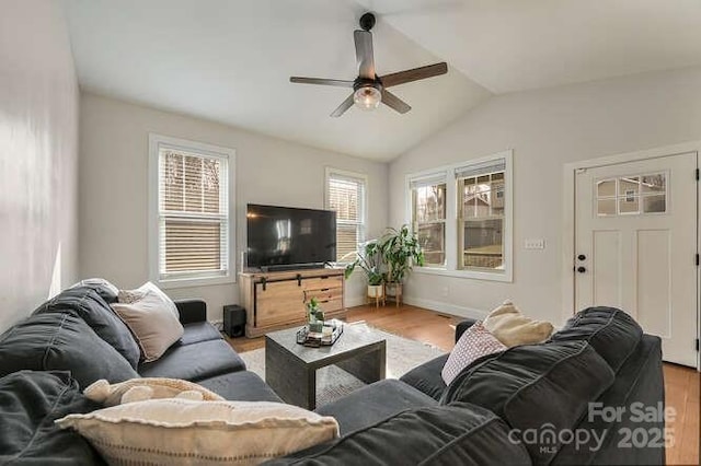 living room featuring a ceiling fan, lofted ceiling, baseboards, and wood finished floors