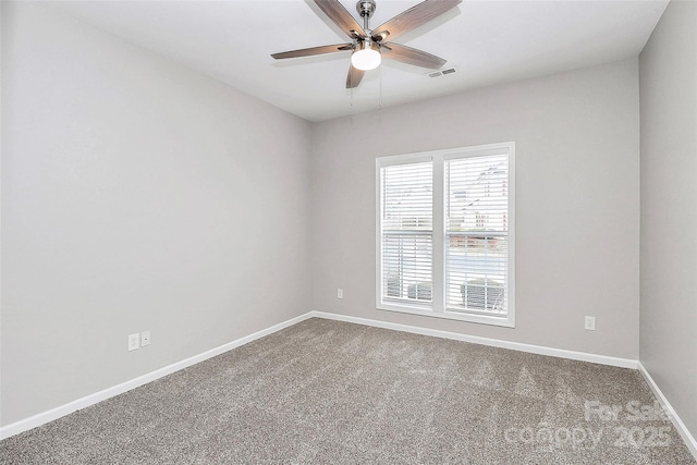 carpeted spare room featuring ceiling fan and baseboards