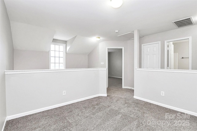 additional living space with carpet floors, visible vents, vaulted ceiling, and baseboards