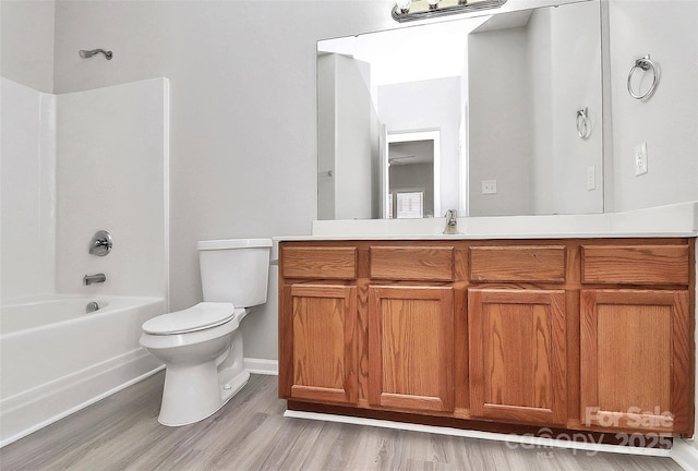 bathroom with  shower combination, vanity, toilet, and wood finished floors