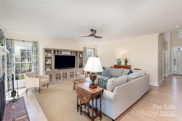 living room with ceiling fan, light hardwood / wood-style floors, and crown molding