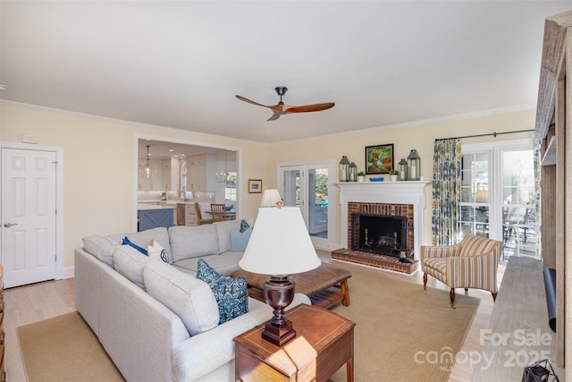 living room featuring crown molding, light wood-type flooring, and a wealth of natural light