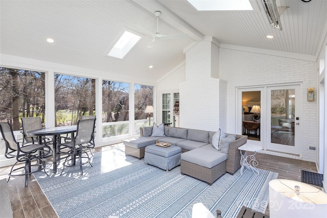 sunroom with french doors, ceiling fan, and vaulted ceiling with skylight