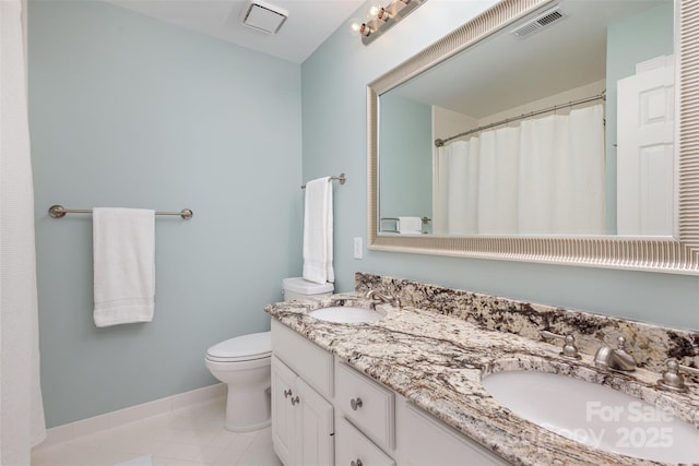 bathroom featuring vanity, tile patterned flooring, and toilet