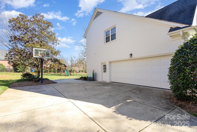 view of side of property with a yard, a playground, and a garage