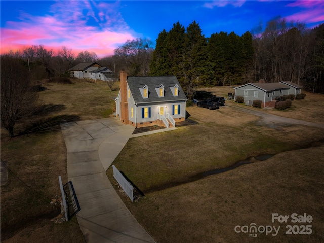 view of front of house featuring driveway, a chimney, crawl space, fence, and a yard