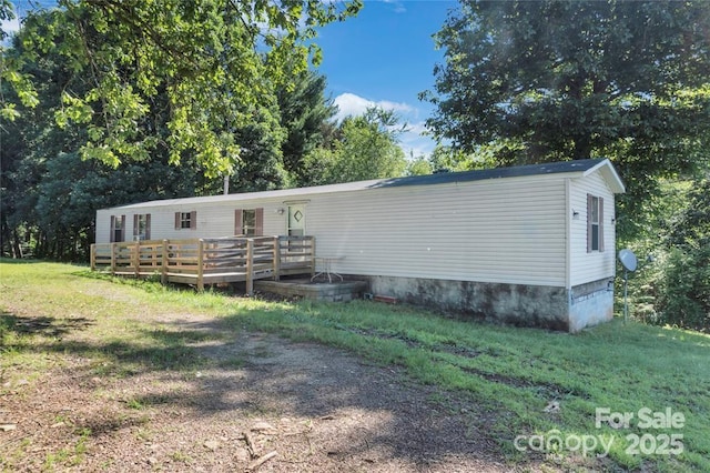 manufactured / mobile home featuring a deck and a front lawn