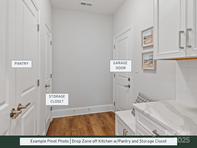 washroom featuring visible vents, baseboards, and wood finished floors