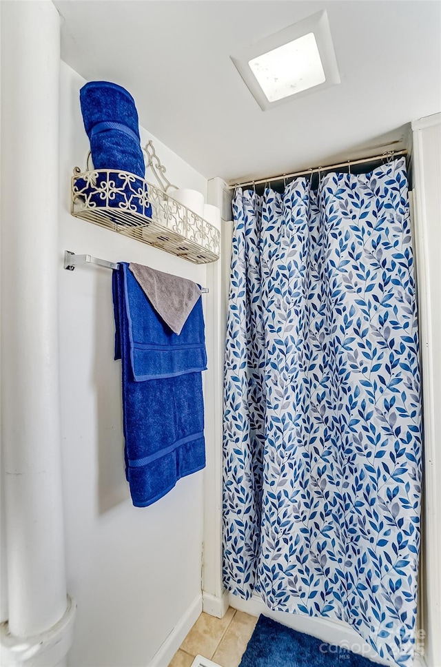 bathroom with curtained shower and tile patterned flooring