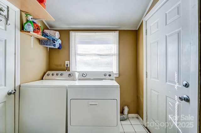 laundry room with laundry area, washing machine and dryer, and light tile patterned floors