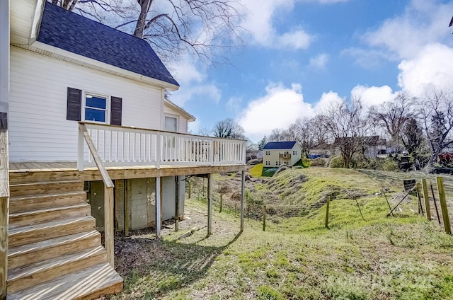 view of yard featuring fence, a deck, and stairs