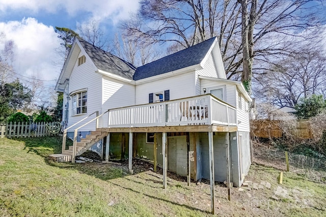 back of house with a shingled roof, a wooden deck, stairs, fence, and a yard