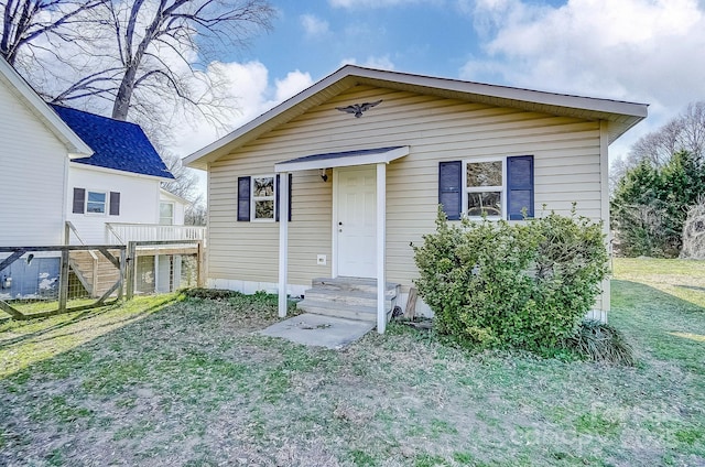 bungalow-style house with entry steps and a front yard