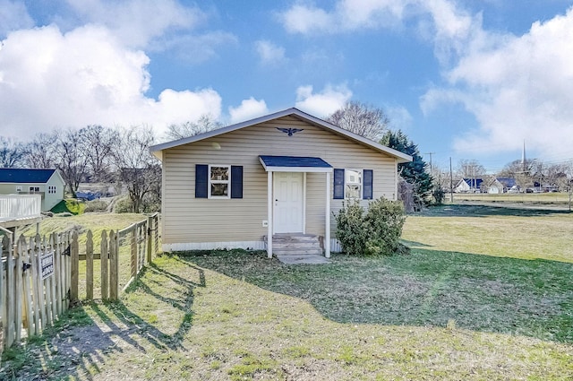 view of front of house featuring a front yard, fence, and entry steps