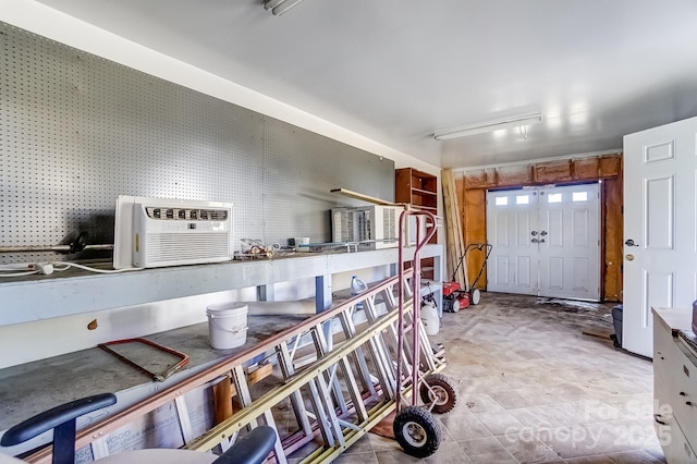 garage with an AC wall unit and a workshop area