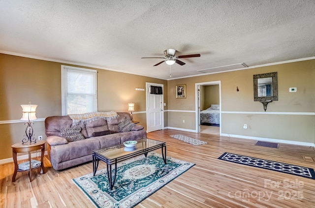 living area featuring ornamental molding, wood finished floors, and baseboards