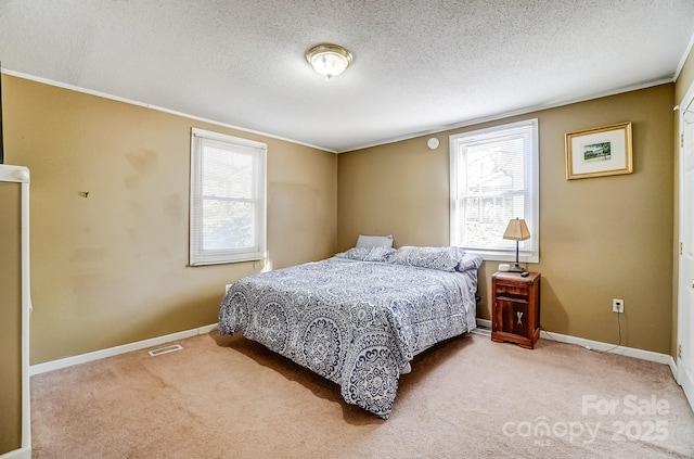 carpeted bedroom featuring visible vents, baseboards, and a textured ceiling