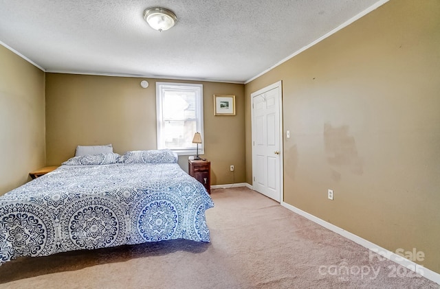 bedroom with crown molding, a textured ceiling, carpet flooring, and baseboards