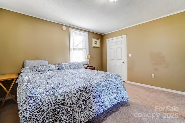 bedroom with carpet floors, baseboards, a textured ceiling, and ornamental molding