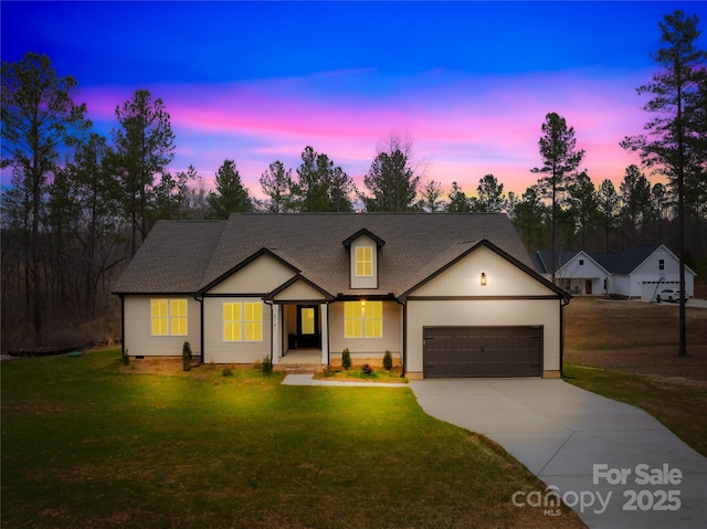 view of front of property with a garage and a yard