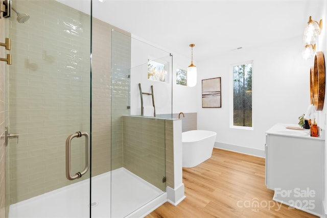 5147 Star Magnolia Ct, Clover, SC 29710 - bathroom featuring baseboards, wood finished floors, a freestanding tub, vanity, and a stall shower