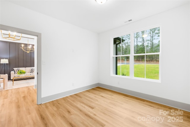 5147 Star Magnolia Ct, Clover, SC 29710 - spare room with baseboards, visible vents, light wood-type flooring, and an inviting chandelier