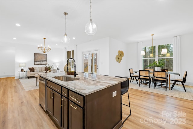 5147 Star Magnolia Ct, Clover, SC 29710 - kitchen with an inviting chandelier, a sink, dark brown cabinetry, and light wood-type flooring