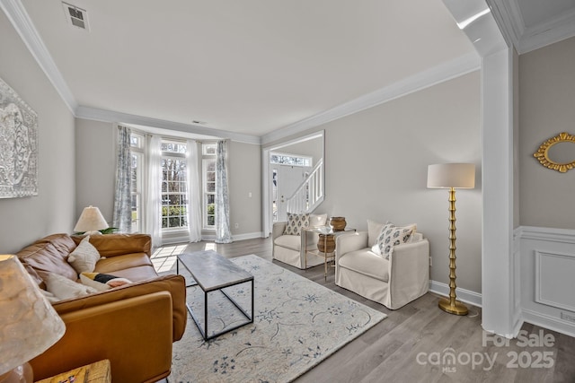 living room featuring ornamental molding and light hardwood / wood-style flooring