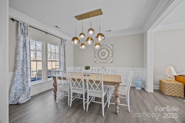 dining area featuring ornamental molding, breakfast area, and wood-type flooring