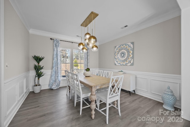 dining area featuring an inviting chandelier, hardwood / wood-style flooring, and ornamental molding