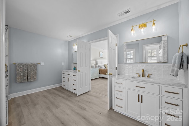 bathroom with hardwood / wood-style flooring, vanity, and tasteful backsplash