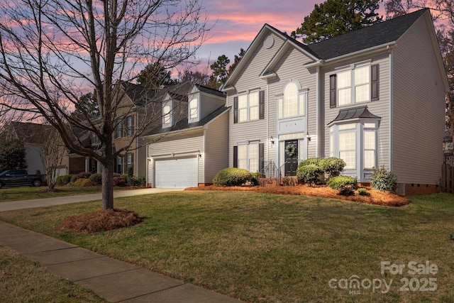 view of front facade with a yard and a garage