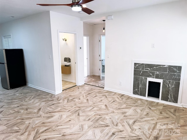 unfurnished living room with baseboards and a ceiling fan