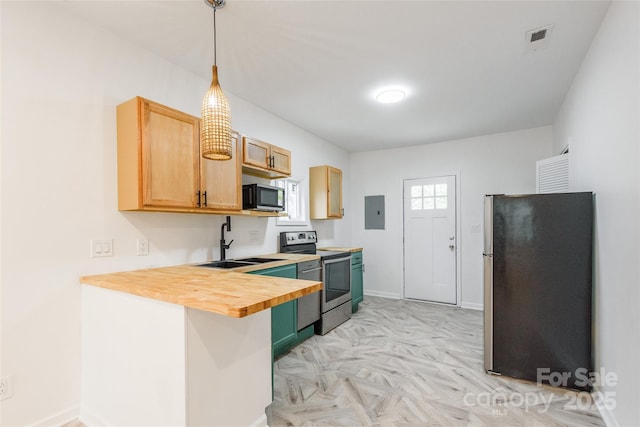 kitchen featuring electric panel, butcher block counters, stainless steel appliances, light brown cabinets, and pendant lighting