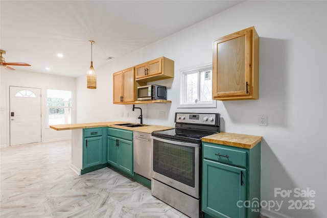 kitchen featuring a healthy amount of sunlight, pendant lighting, stainless steel appliances, and a sink