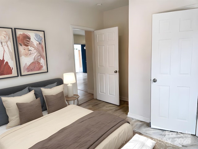 bedroom featuring light wood-style flooring and baseboards