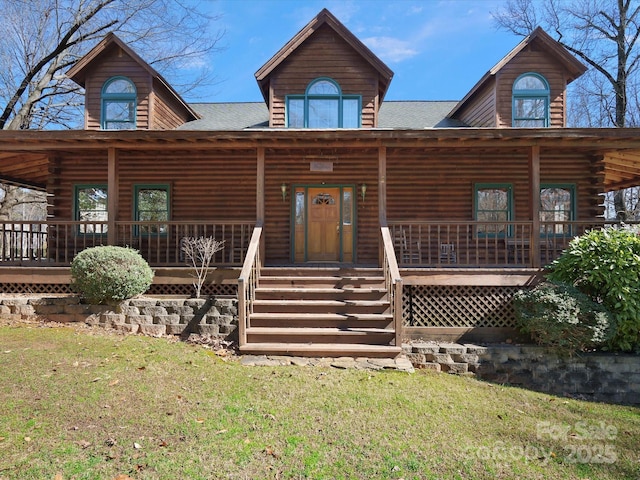 log home with covered porch and a front yard