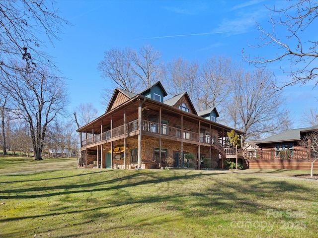 rear view of house featuring stone siding, a lawn, and a deck