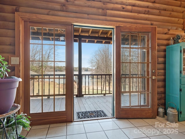 entryway with light tile patterned floors and rustic walls