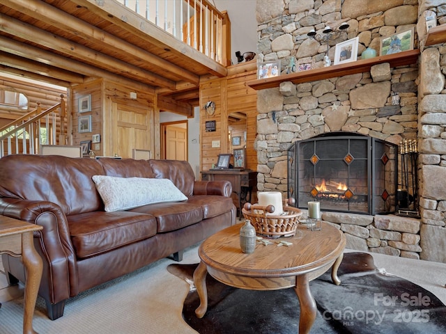 living area with carpet flooring, a stone fireplace, and a wall unit AC