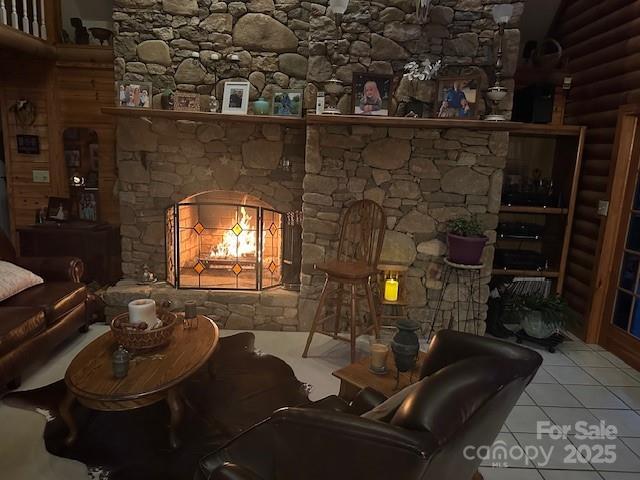 interior space featuring a lit fireplace, rustic walls, and tile patterned floors