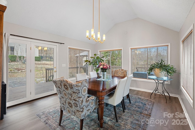 dining room featuring lofted ceiling, dark wood finished floors, baseboards, and an inviting chandelier