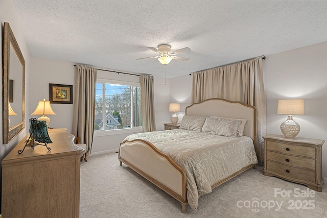 bedroom featuring baseboards, a ceiling fan, a textured ceiling, and light colored carpet