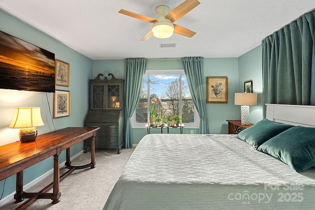 bedroom with visible vents, a ceiling fan, light carpet, a textured ceiling, and baseboards