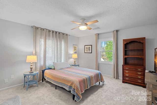 bedroom with light carpet, ceiling fan, a textured ceiling, and baseboards