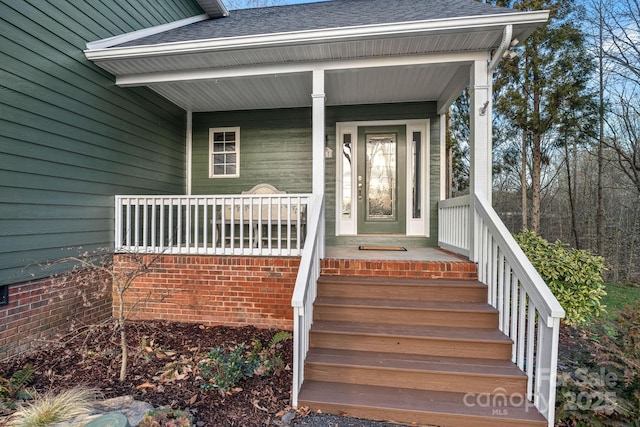 view of exterior entry with a shingled roof